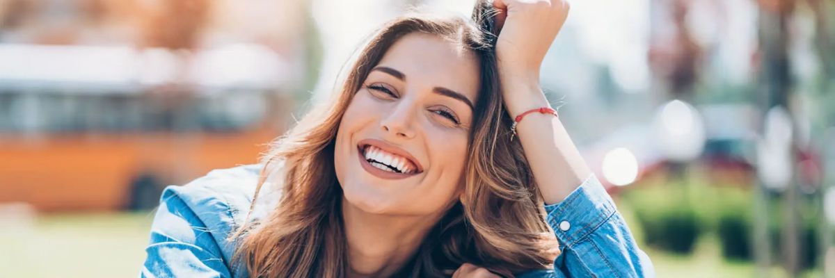 Patient smiling after recovering their dental implant at OV Dental Studio